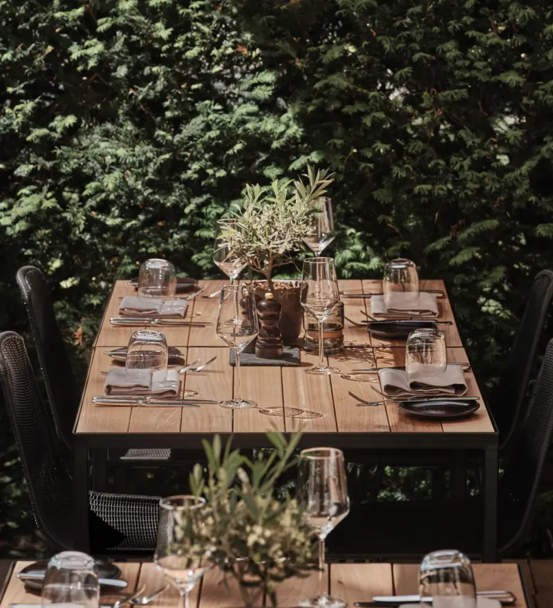 Gedeckte Tische auf der begrünten Terrasse